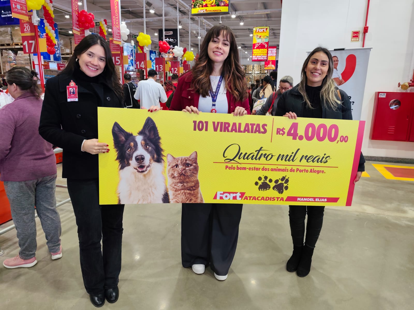 Foto: divulgação/Silvia Marquez e Ketni Chaves, do Fort Atacadista, entregam cheque à Franciele Amaral, da 101 Viralatas