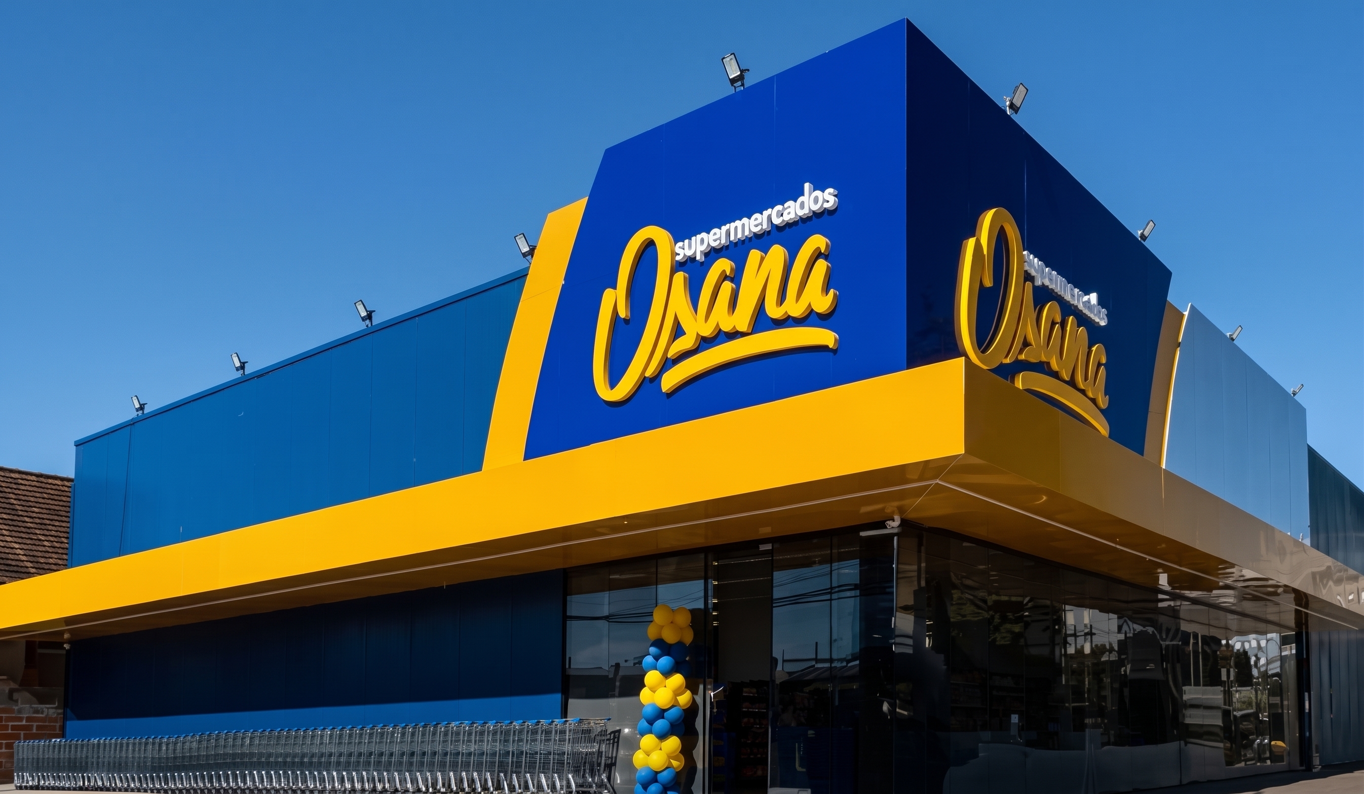 Fachada do Supermercados Osana - na frente bexigas e uma fila de carrinhos de supermercado