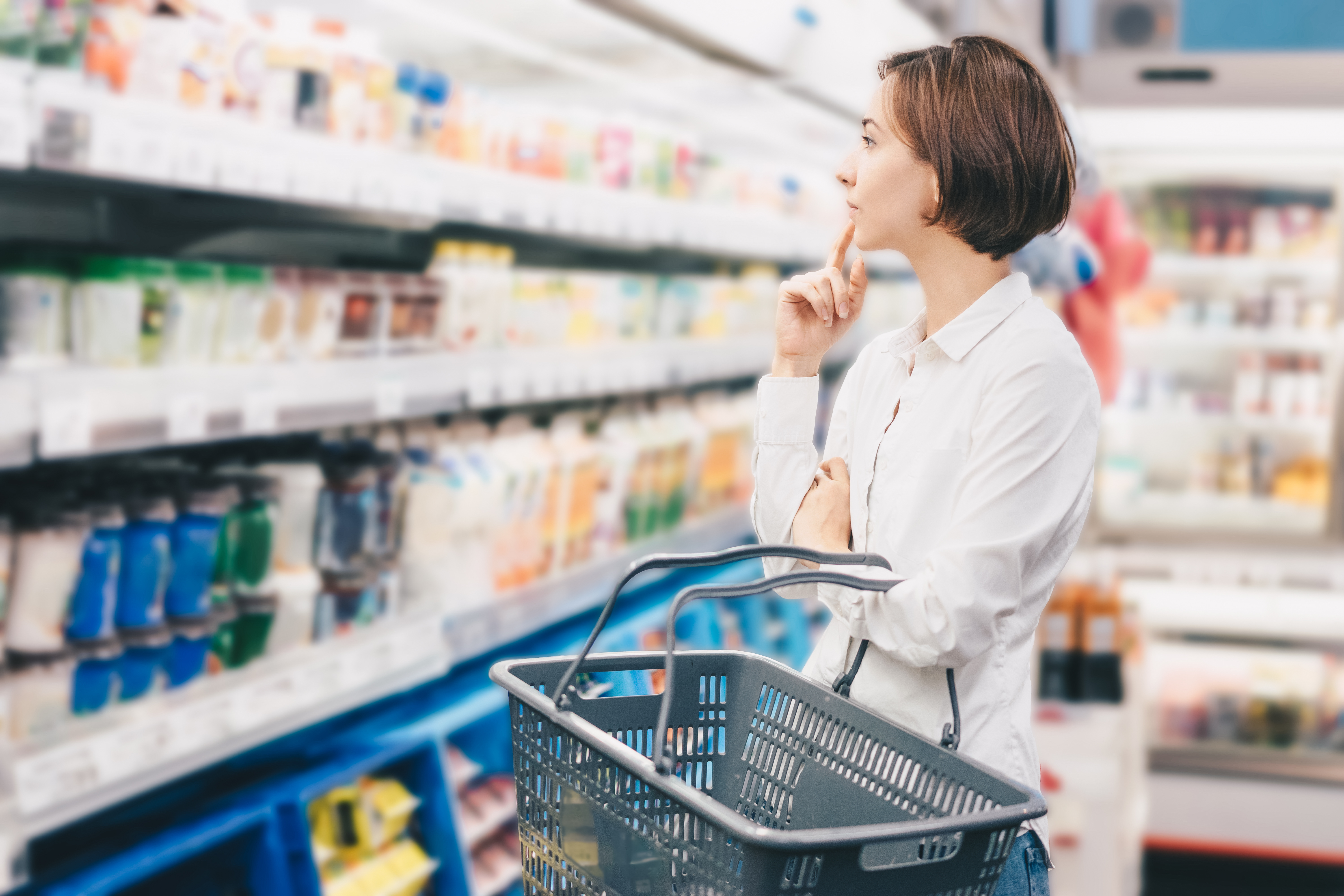Mulher no supermercado com cesta de compras