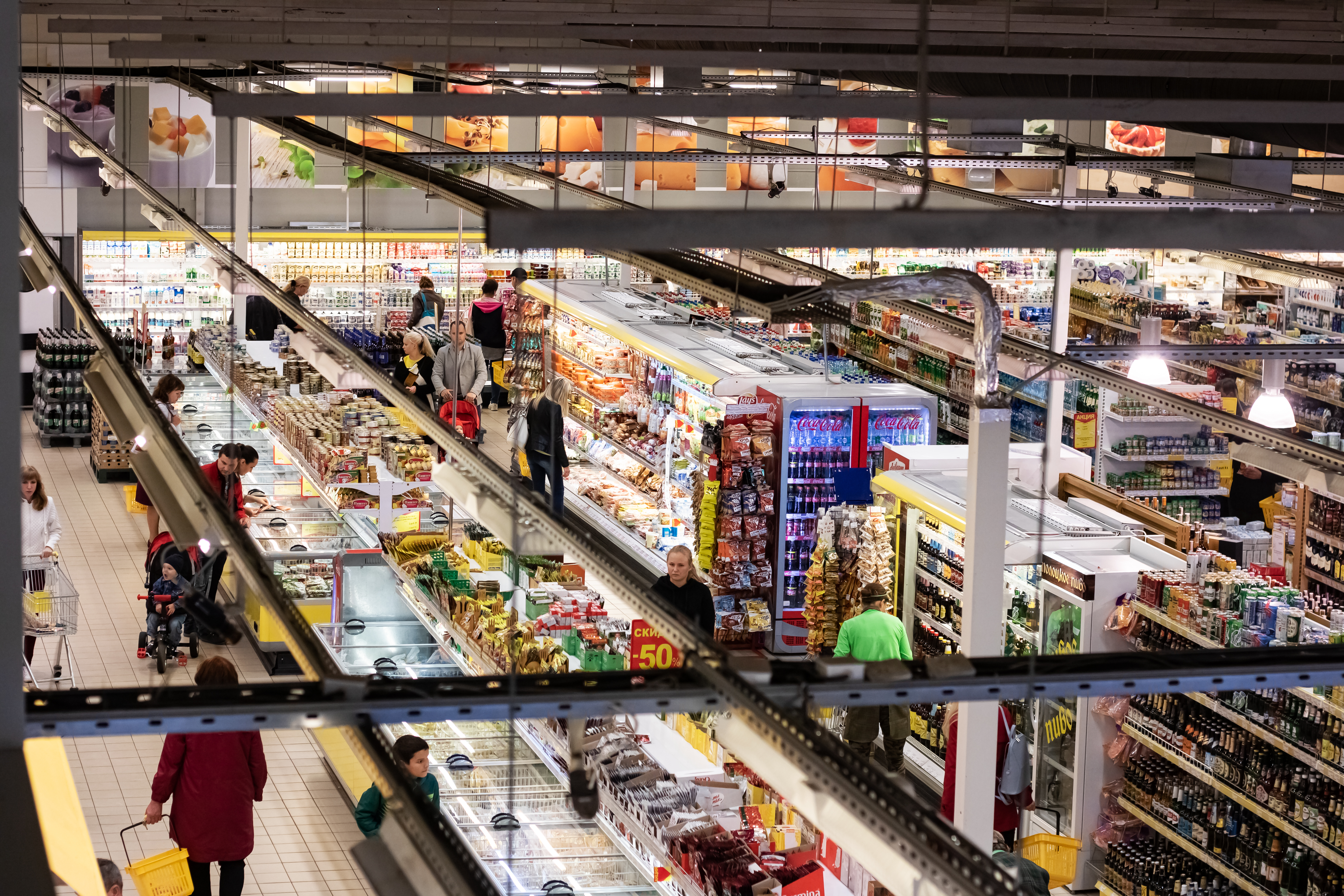 Visão aérea da parte interior de um supermercado com consumidores circulando