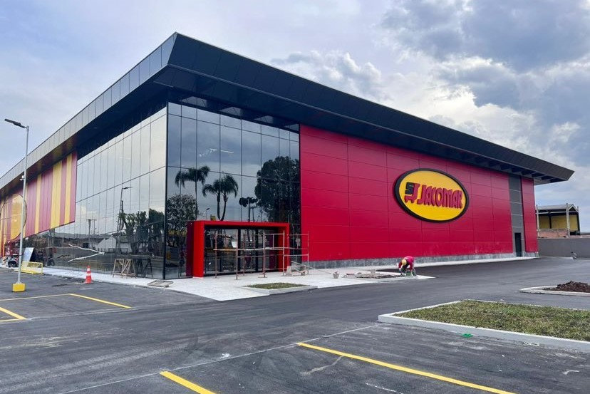 Fachada do Supermercado Jacomar que estende a uma parte do estacionamento
