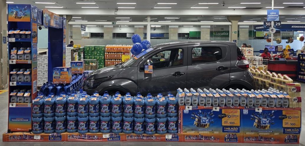 Um carro rodeado de produtos YPÊ em uma loja de supermercado