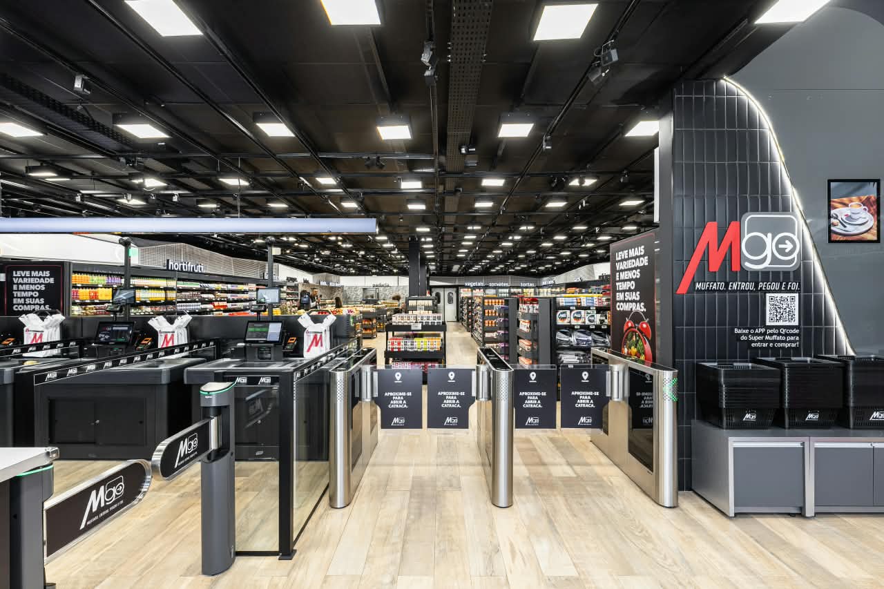 Entrada de supermercado autonômo por catracas automáticas e logo MGO à esquerda